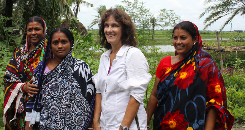 Beth Mitcham stands smiling with three women in saris