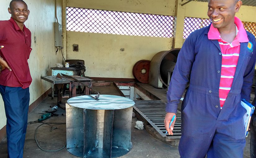 students with metal water wheel in workshop