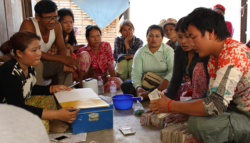 man counting cash while group members watch