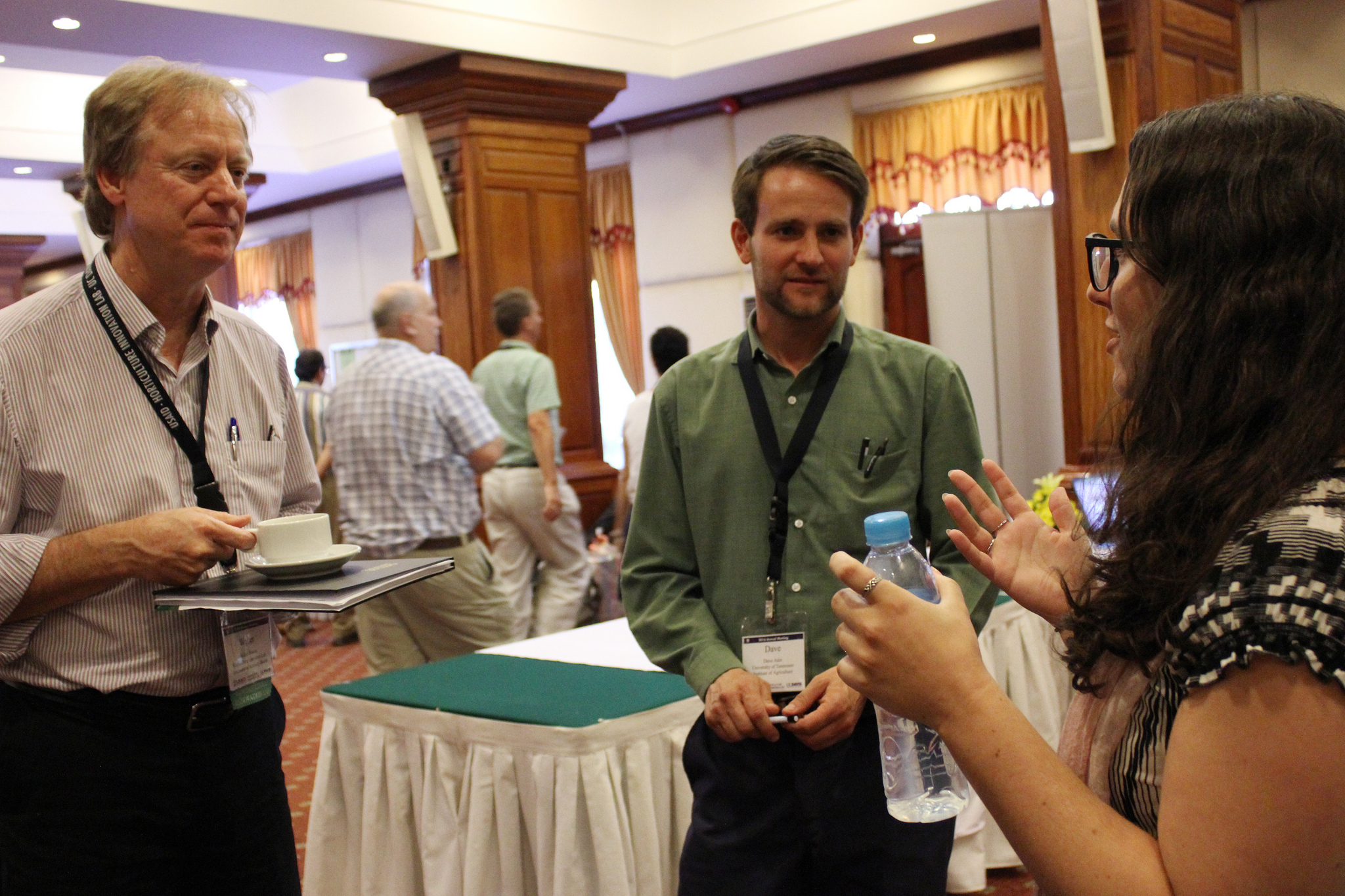 Three people talking in a hotel ballroom