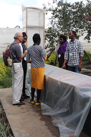 International group of scientists talking and standing around chimney solar dryer