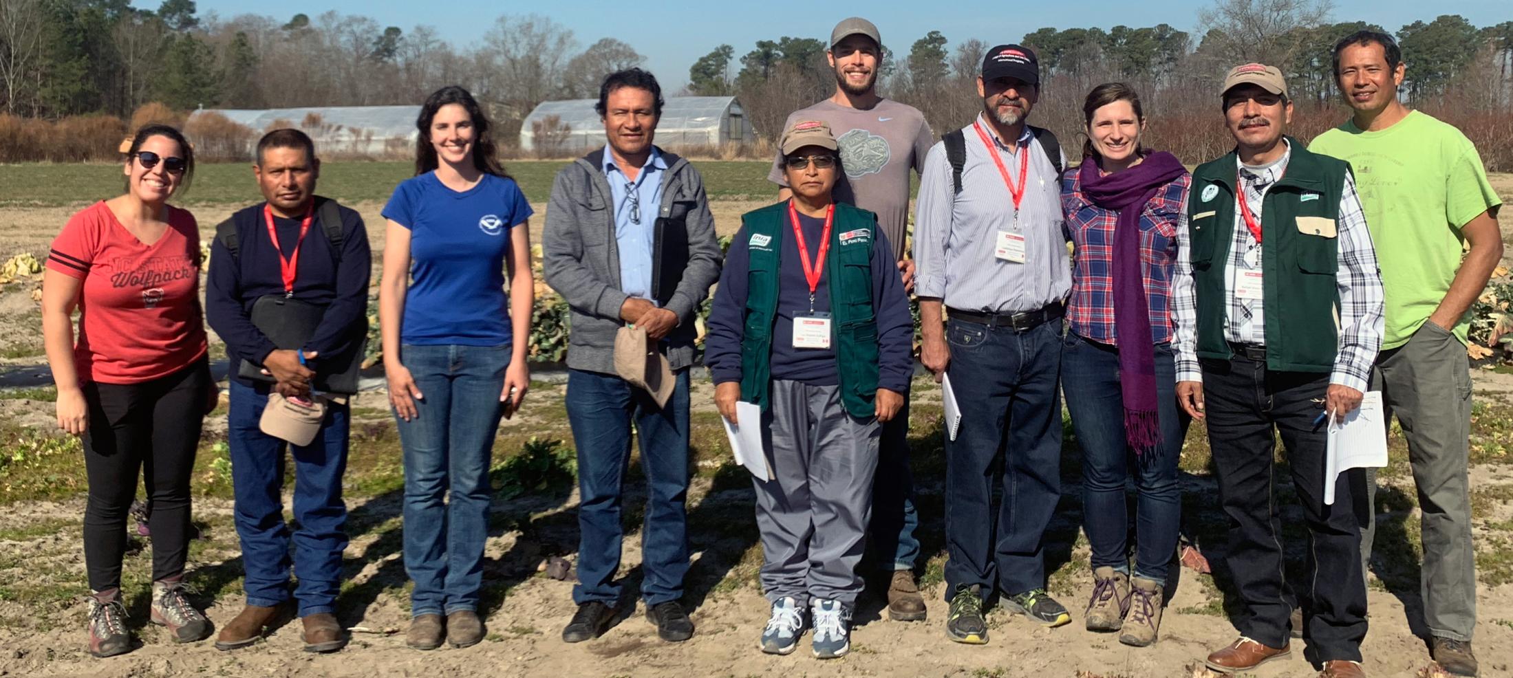 Angel Cruz pictured in a field with other researchers