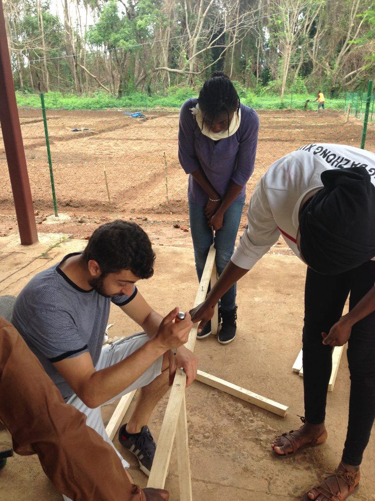 Researcher helps build wooden solar dryer frame