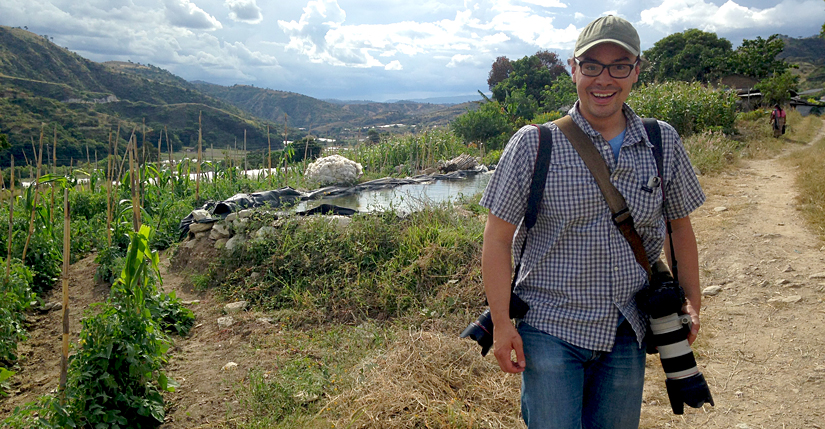 Photojournalist smiling, crops behind him