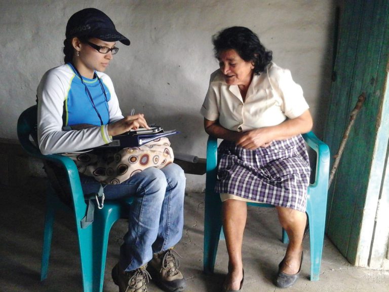 Young woman and old woman talking in plastic chairs