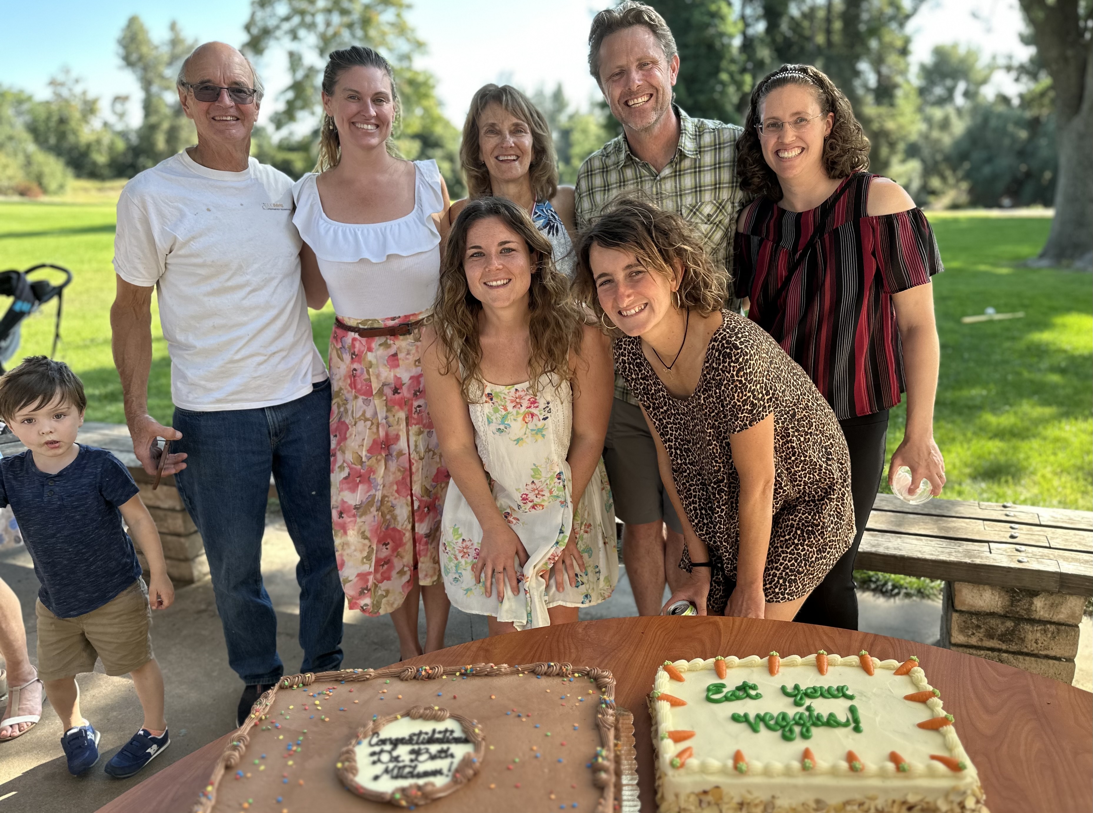 Group surrounding cake for retirement celebration.