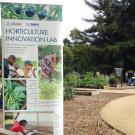 Horticulture Innovation Lab sign in front of garden path with groups of people looking at demonstrations