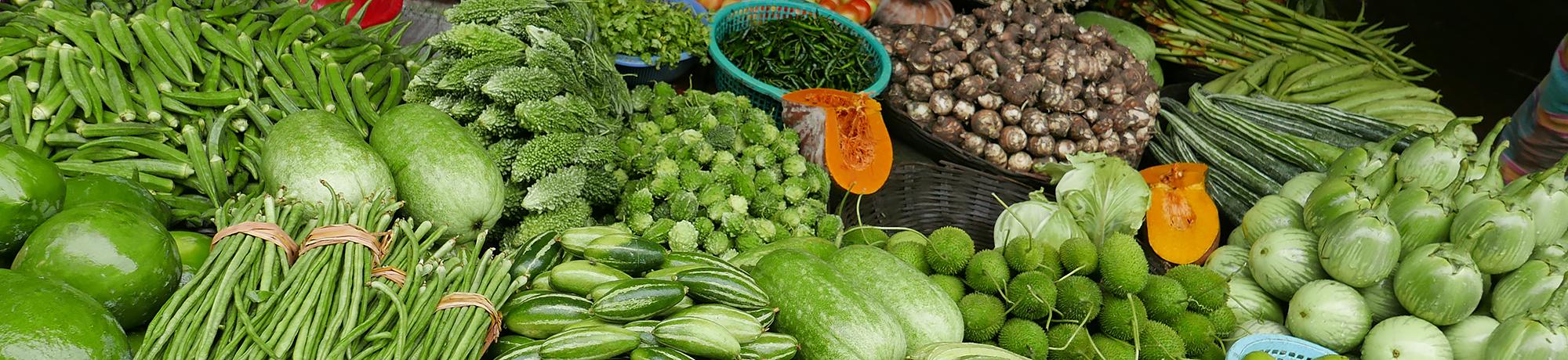 Fresh vegetables at a market in Bangaldesh, long beans, eggplant, squash, peppers, okra, bittermelon, herbs, root vegetables, cabbage, melons